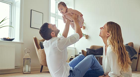 couple playing with their baby in the living room