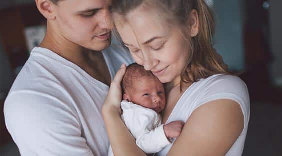 couple hugging their baby