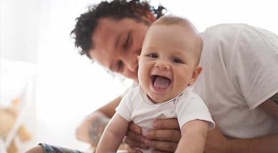 dad playing with baby smiling