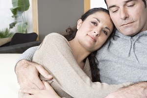 couple hugging on sofa at home