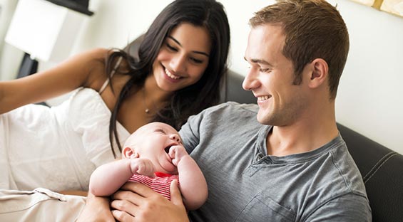 couple holding baby smiling