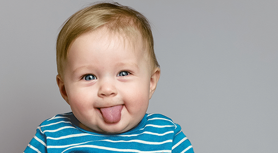 About First Step Fertility 2 cute boy sticking tongue out with blue and white striped shirt